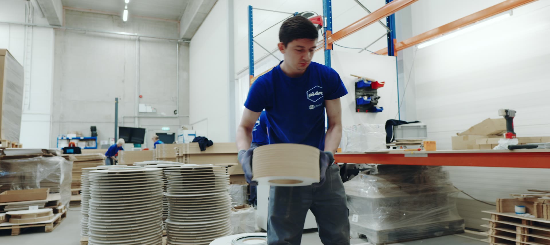 A Piar worker stacking cut display parts at the packing station.